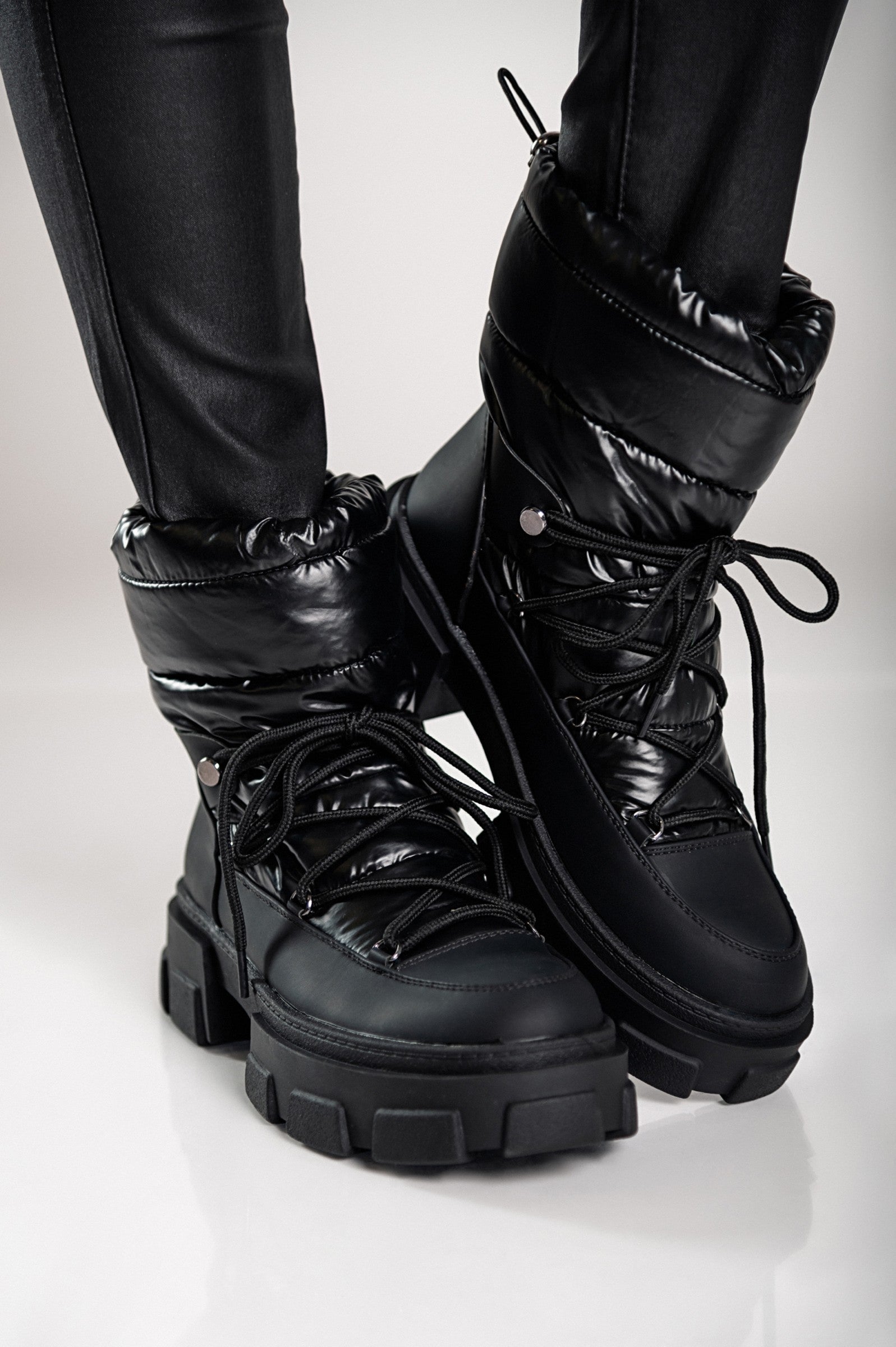 Warm black ankle boots with laces, featuring a round toe and raised sole, perfect for stylish comfort.