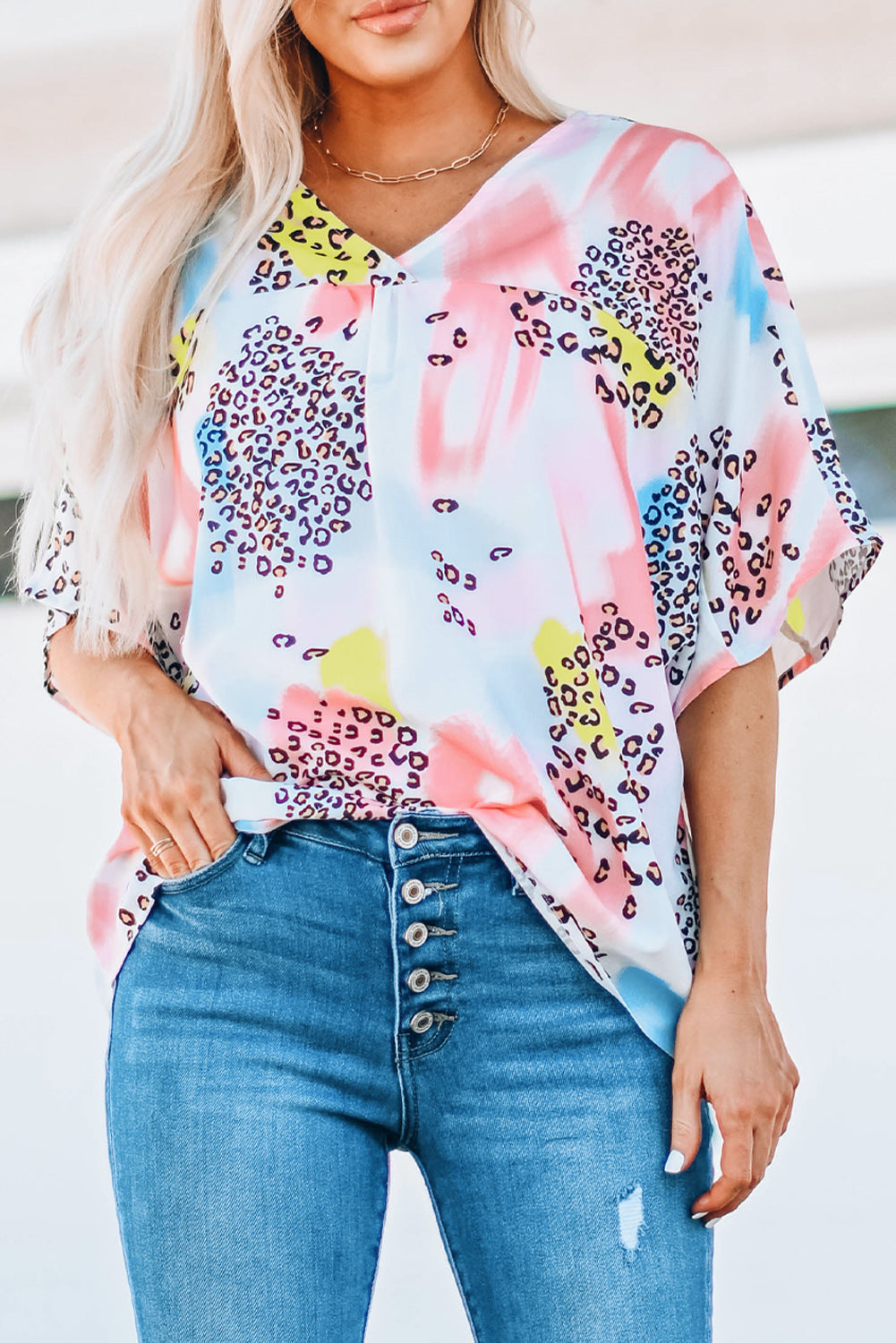 A vibrant Watercolor Print Loose Top featuring an oversized fit, v-neck design, and colorful animal print details, perfect for summer wear.