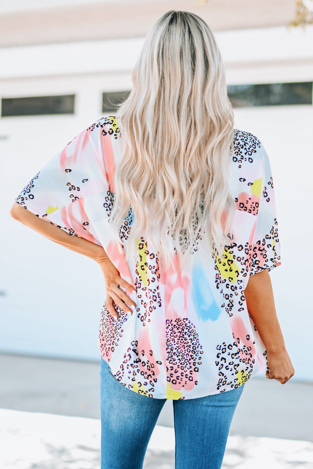A vibrant Watercolor Print Loose Top featuring an oversized fit, v-neck design, and colorful animal print details, perfect for summer wear.