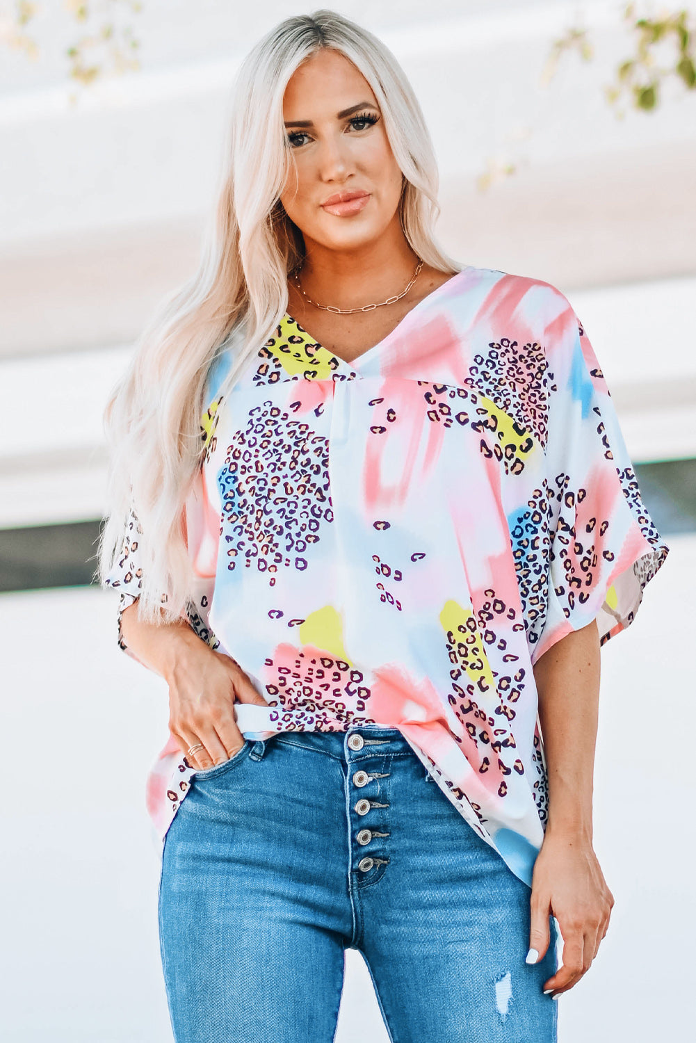 A vibrant Watercolor Print Loose Top featuring an oversized fit, v-neck design, and colorful animal print details, perfect for summer wear.