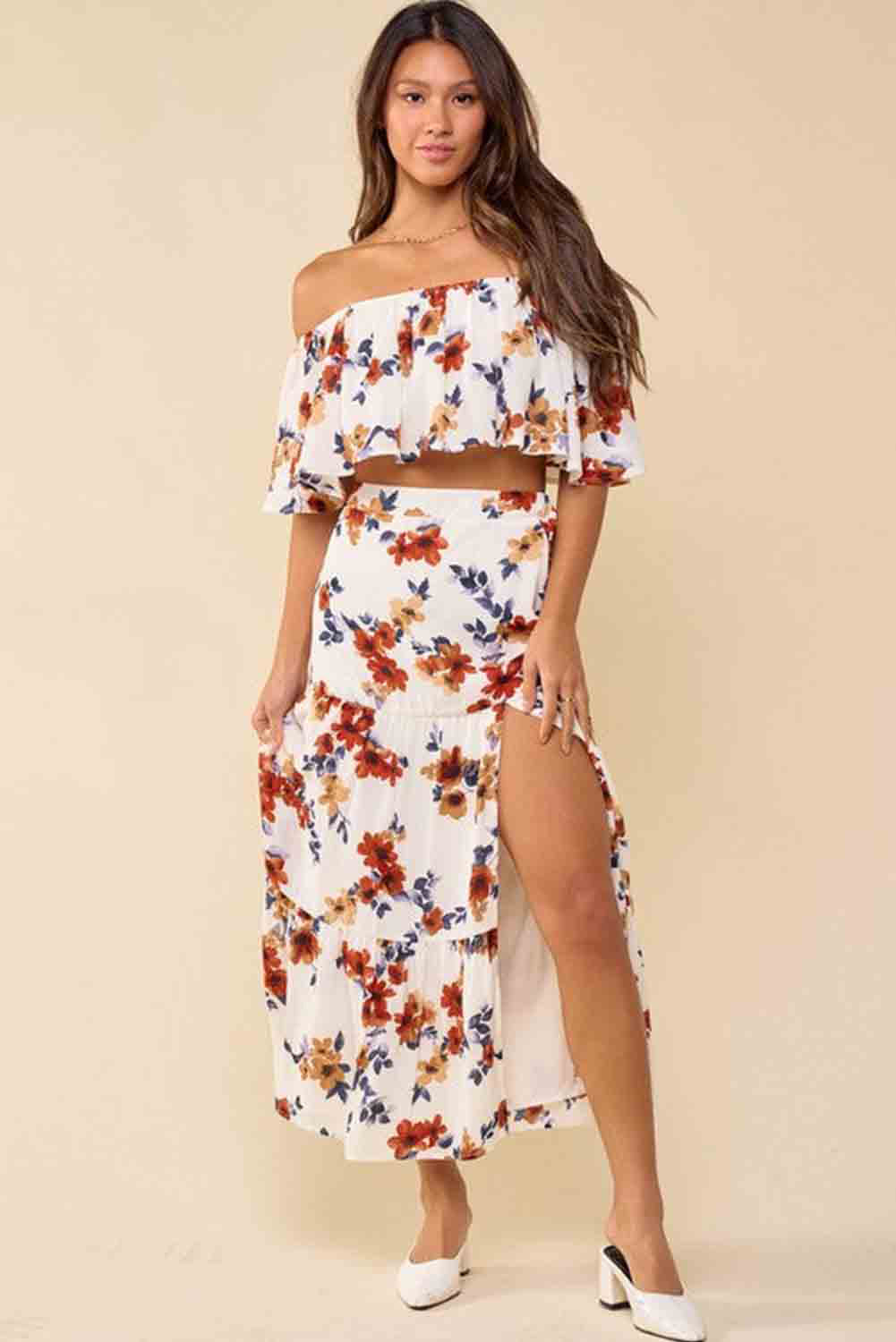 A stylish white floral print off-shoulder crop top paired with a flowing maxi skirt featuring a high slit, perfect for summer outings.