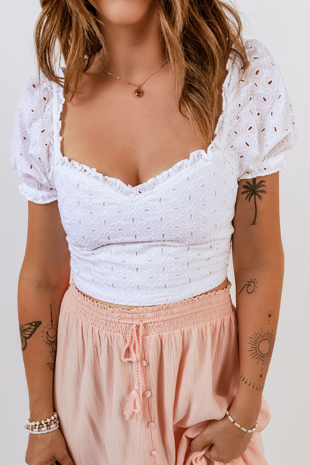 A stylish white lace crochet crop top with puff sleeves, perfect for summer outfits.