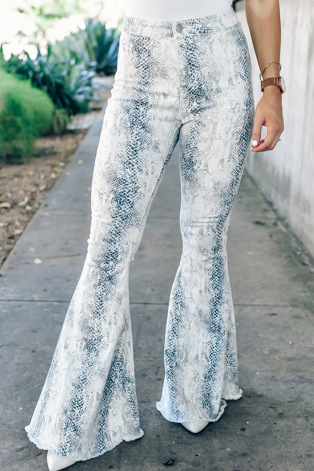 White high waist snakeskin print flare pants displayed on a mannequin, showcasing the trendy design and flattering silhouette.