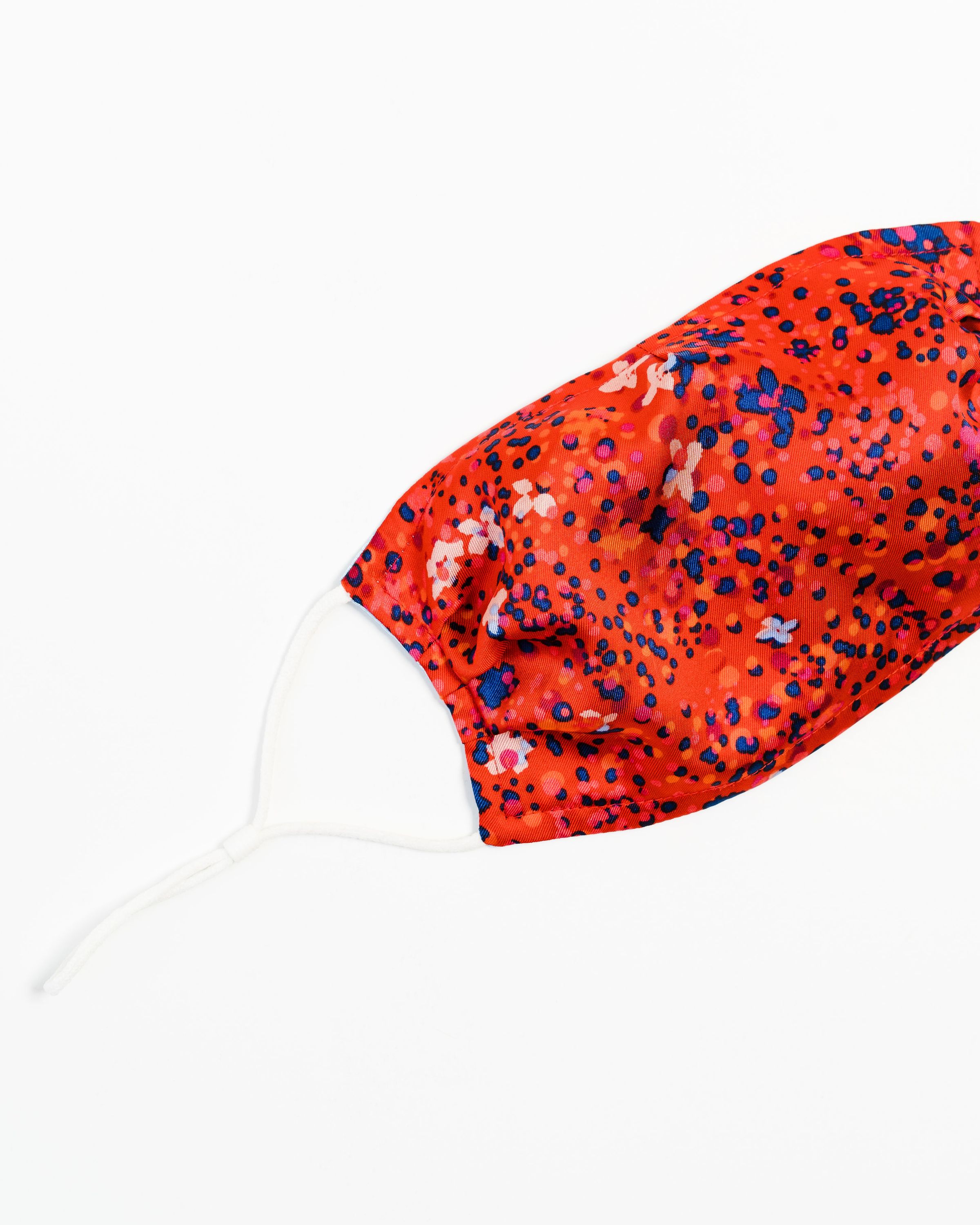 Wildflower Satin Face Mask featuring a reversible design with floral patterns, made of soft satin polyester, adjustable ear loops, and a filter pocket.