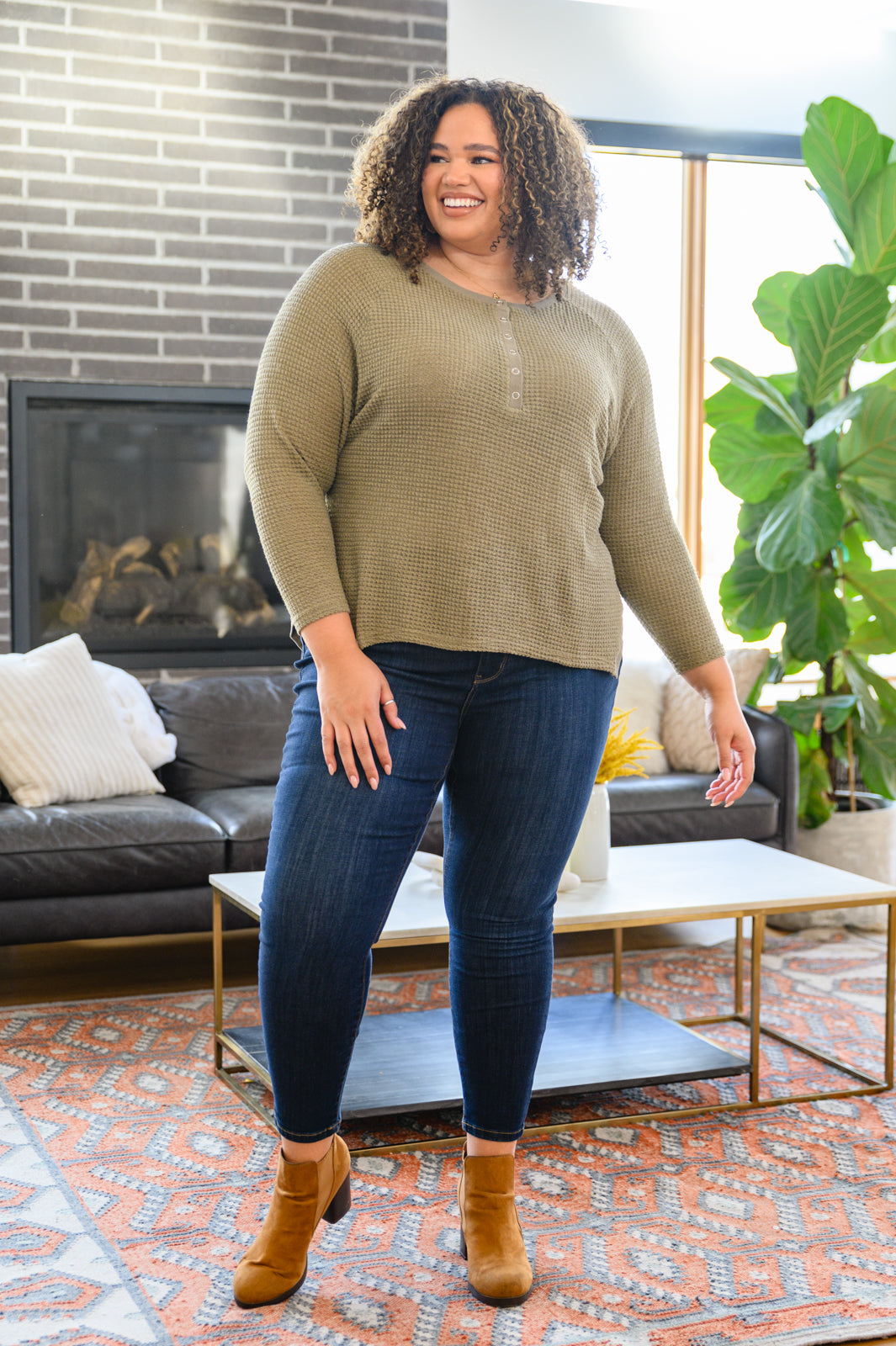 Wishful Thinking Henley in Olive, featuring a henley neckline and sharkbite hem, displayed on a model.