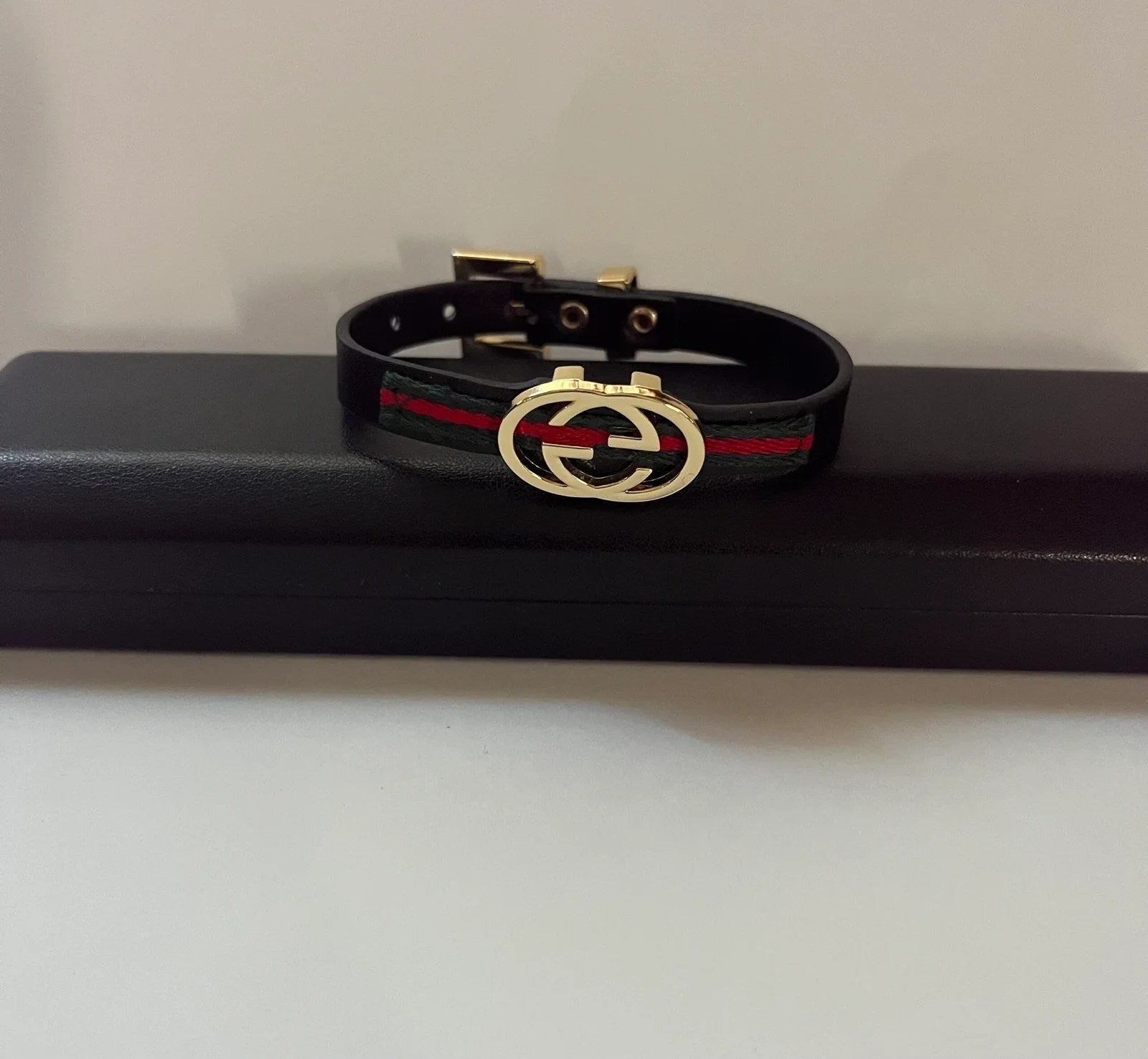 Elegant Gucci Women Bracelet made of genuine leather in gold and black colors, showcasing a stylish design.