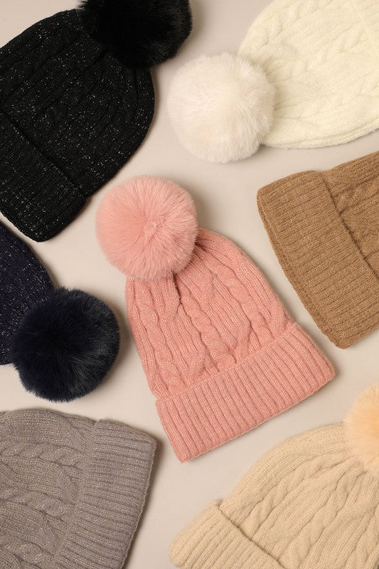 Women's Cable Knitted Lurex Beanie with a faux fur pom pom, showcasing a stylish cable knit pattern in a cozy design.