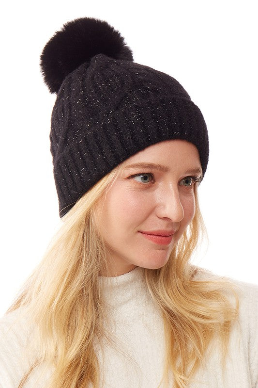 Women's Cable Knitted Lurex Beanie with a faux fur pom pom, showcasing a stylish cable knit pattern in a cozy design.