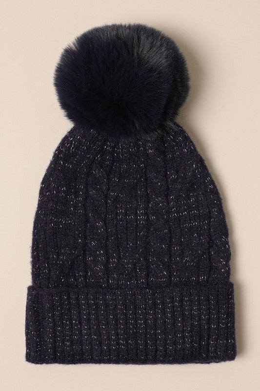 Women's Cable Knitted Lurex Beanie with a faux fur pom pom, showcasing a stylish cable knit pattern in a cozy design.