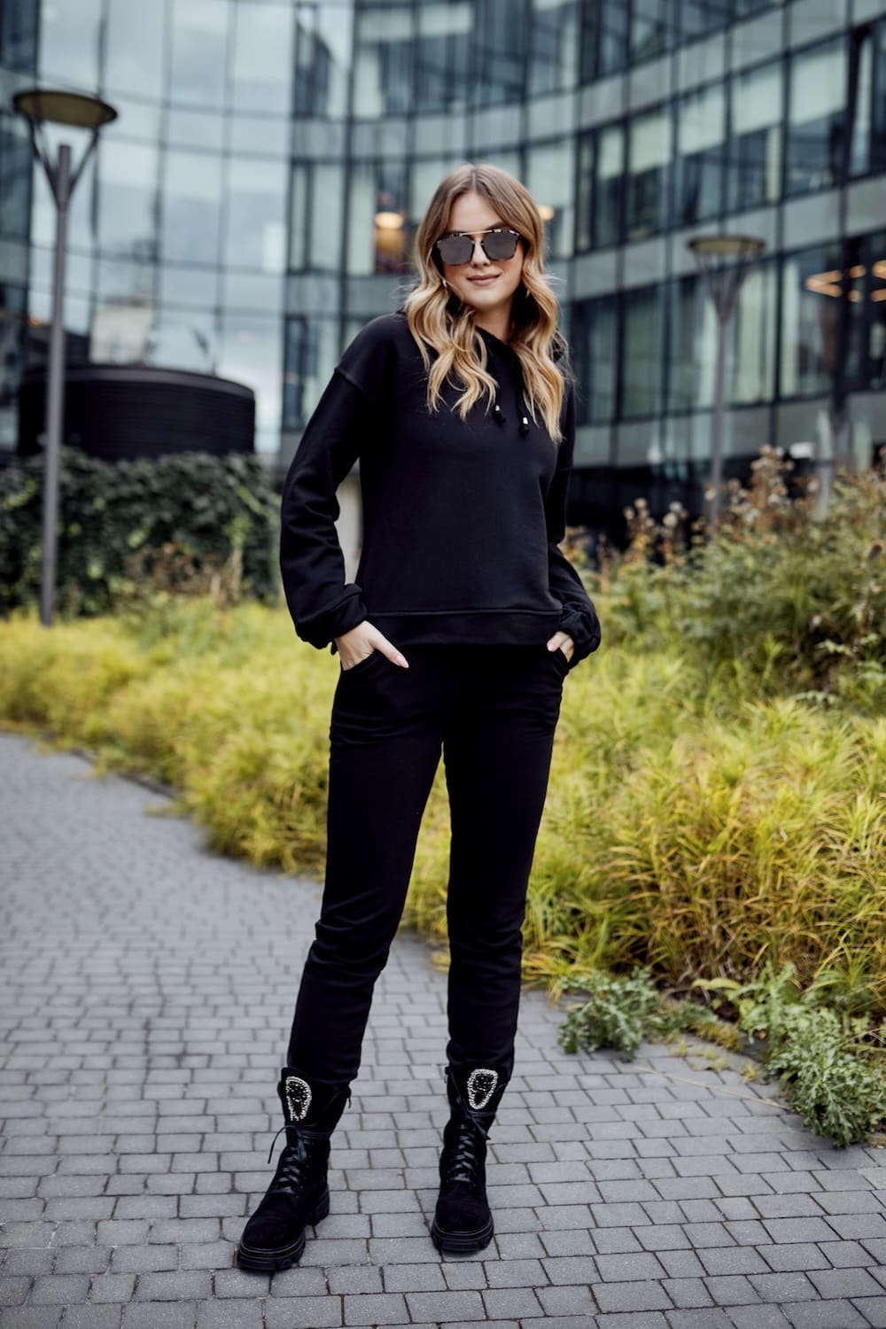 Women's black cotton tracksuit set featuring a hooded sweatshirt and joggers with pockets.