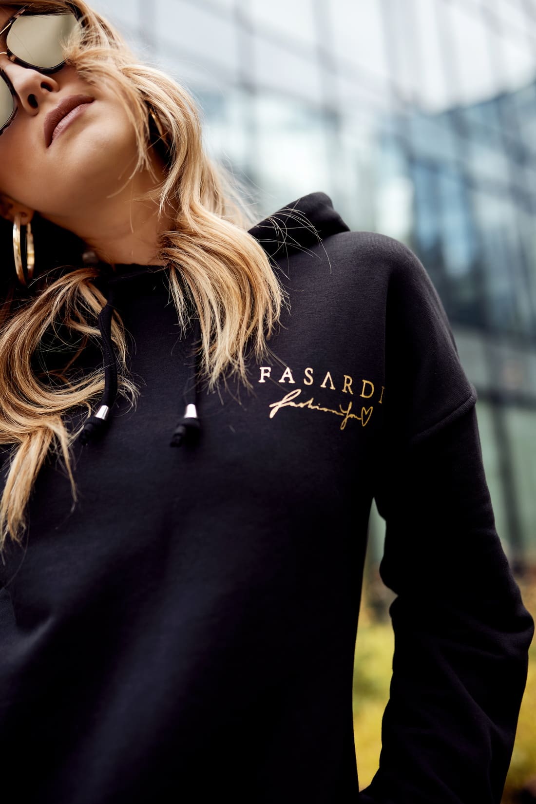 Women's black cotton tracksuit set featuring a hooded sweatshirt and joggers with pockets.