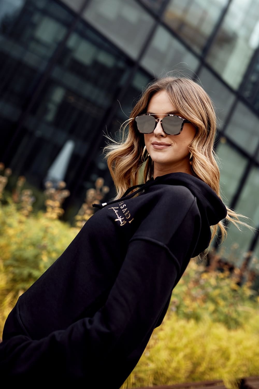 Women's black cotton tracksuit set featuring a hooded sweatshirt and joggers with pockets.