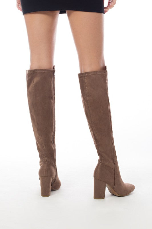 Women's knee-high boots made of faux suede with a block heel, showcasing a stylish design suitable for various outfits.