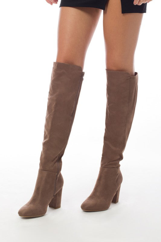 Women's knee-high boots made of faux suede with a block heel, showcasing a stylish design suitable for various outfits.