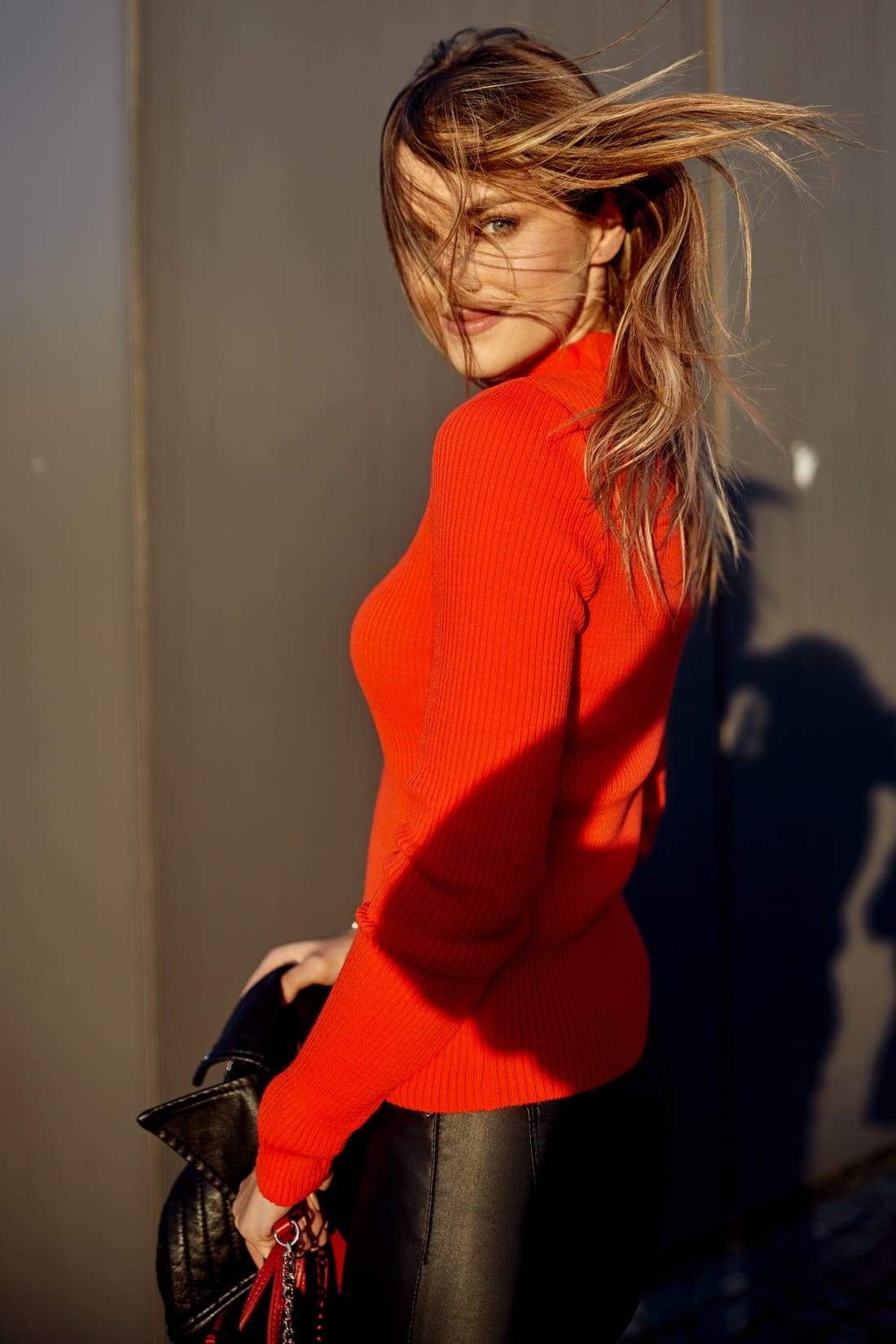 Women's fitted turtleneck sweater in neon orange, featuring long sleeves and ribbed texture, perfect for stylish layering.