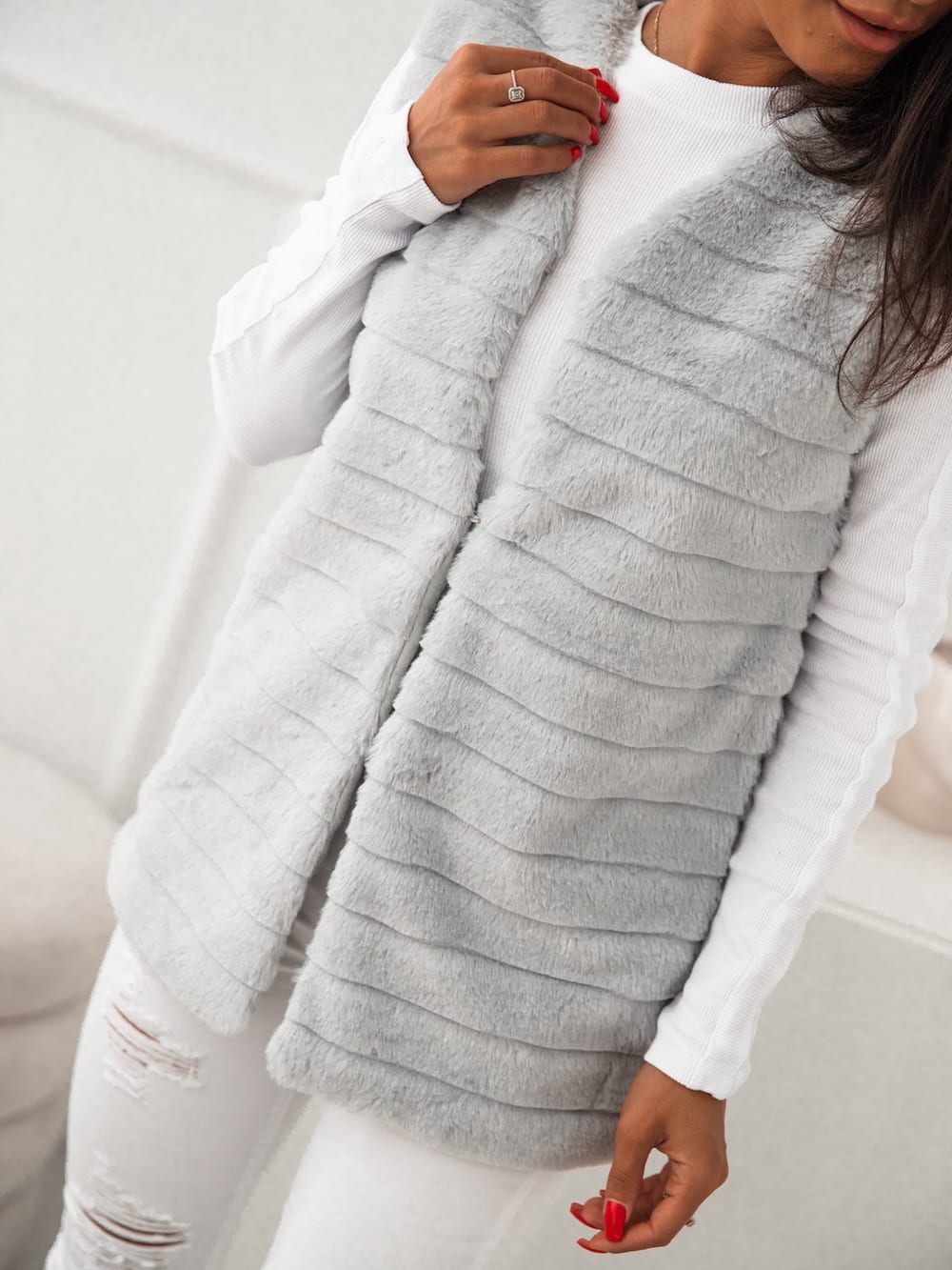 Women's light gray fur vest with V-neckline and hook fastenings, showcasing soft eco-friendly fur material.