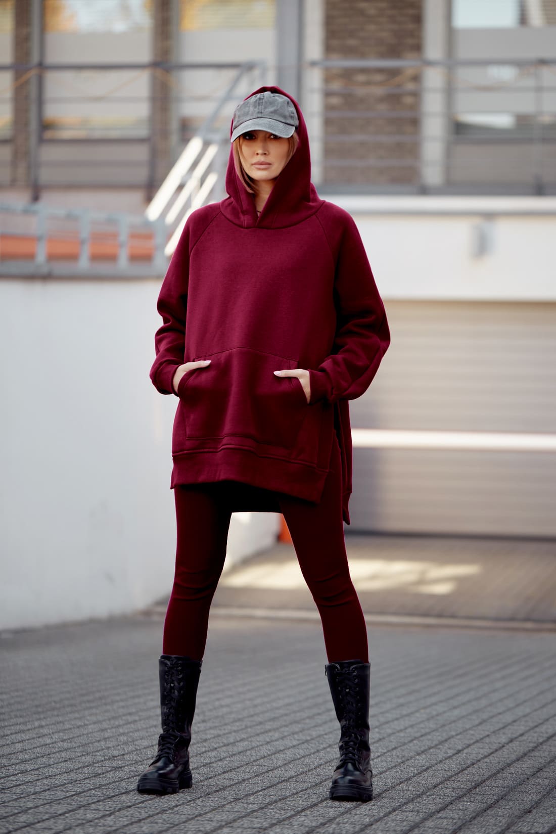 Women's burgundy oversize sweatshirt paired with striped leggings, showcasing a cozy and stylish outfit perfect for casual wear.