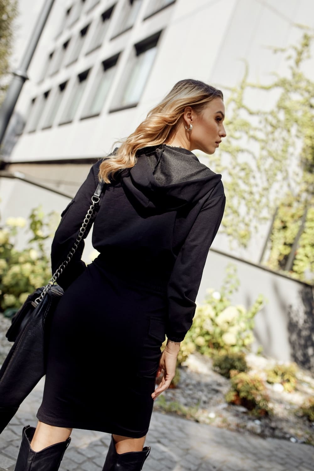 Women's black sports set featuring a wrap front sweatshirt and skirt with cargo pockets, perfect for casual and active wear.