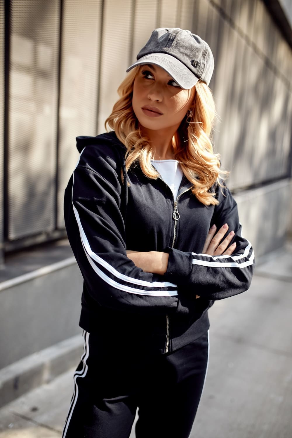 Women's navy blue tracksuit set featuring white stripes, including a loose sweatshirt with a hood and comfortable elastic waist pants.