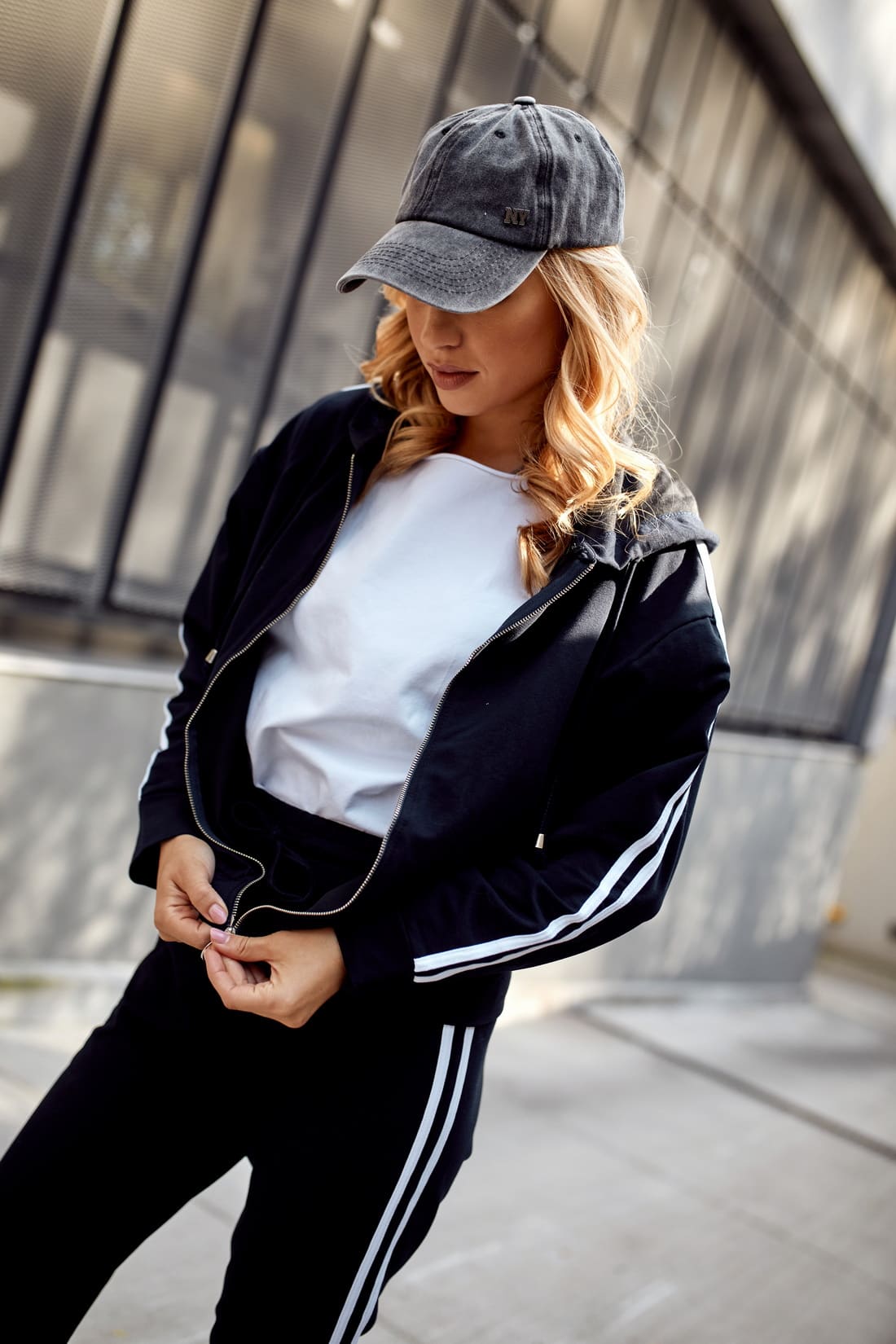 Women's navy blue tracksuit set featuring white stripes, including a loose sweatshirt with a hood and comfortable elastic waist pants.