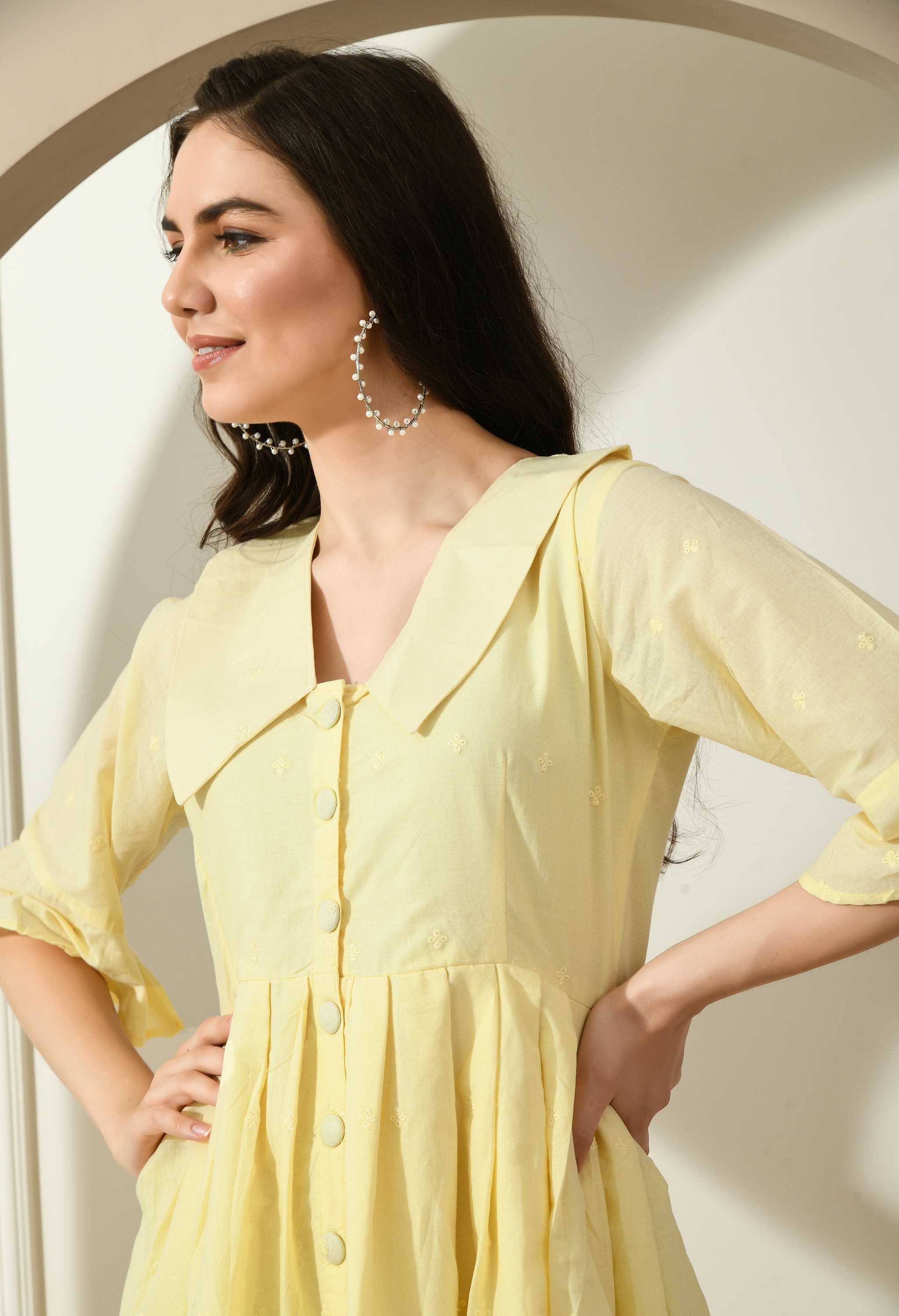 A stylish yellow Hakoba dress featuring big collars, wood buttons, and an A-line fit, perfect for casual occasions.