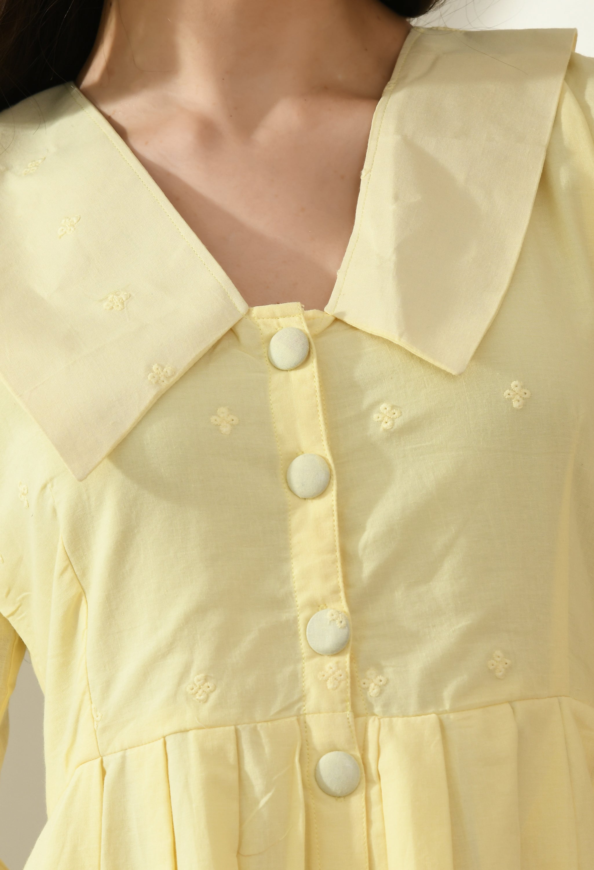 A stylish yellow Hakoba dress featuring big collars, wood buttons, and an A-line fit, perfect for casual occasions.