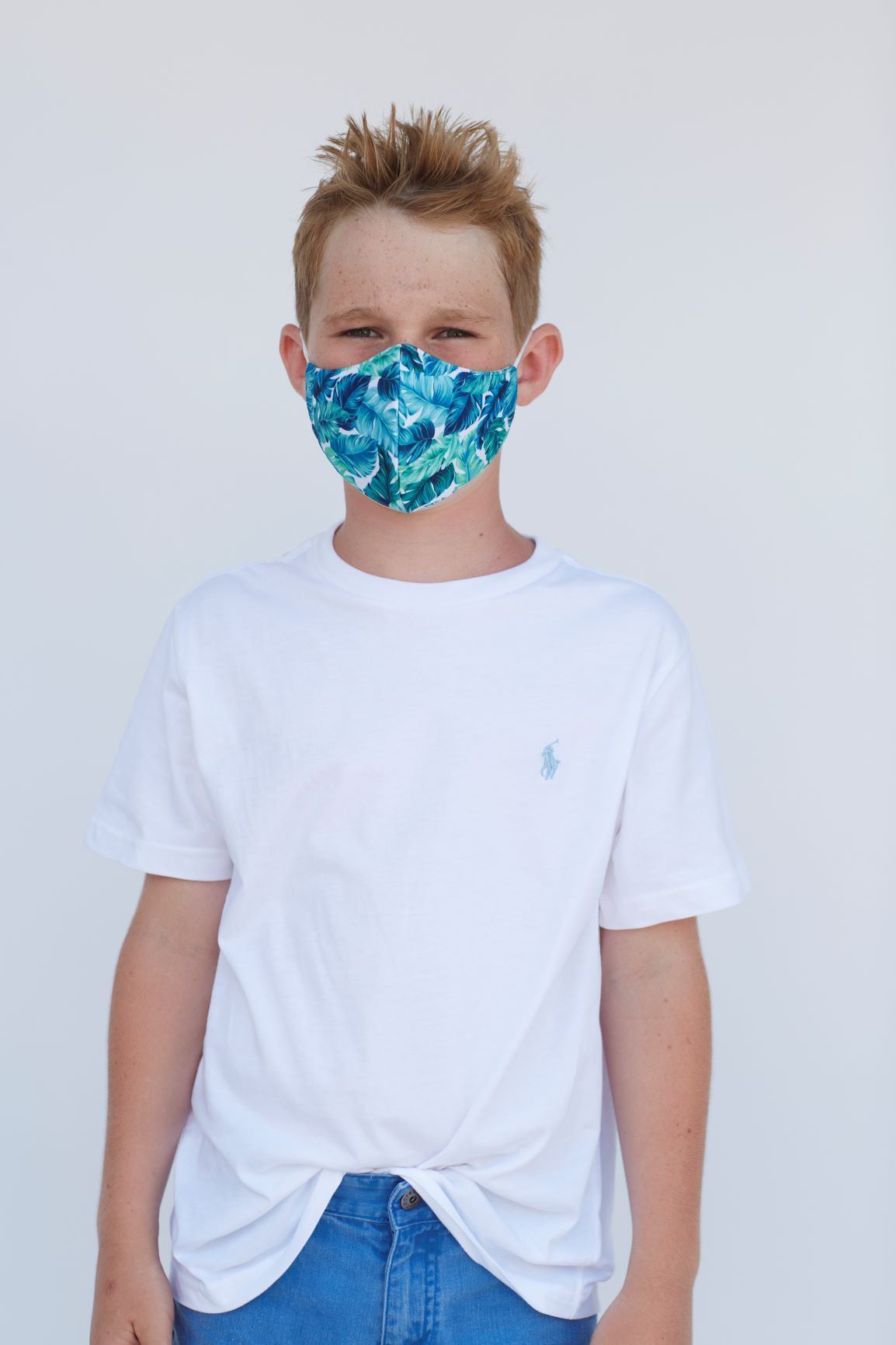 Youth Tropical Banana Leaves Face Mask featuring a vibrant tropical design, made of breathable cotton and polyester layers.