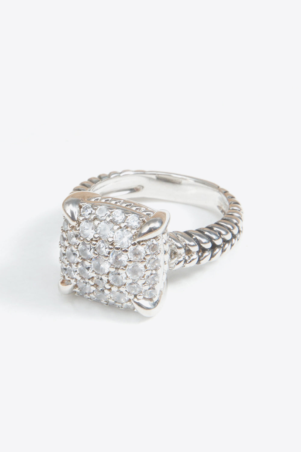 Zircon Twisted Ring featuring a minimalist design, crafted from zircon and copper with an 18k platinum-plated finish, displayed in a flat lay style.