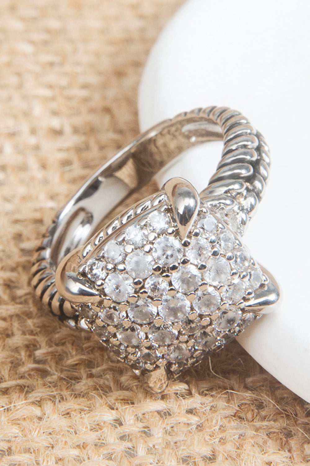 Zircon Twisted Ring featuring a minimalist design, crafted from zircon and copper with an 18k platinum-plated finish, displayed in a flat lay style.